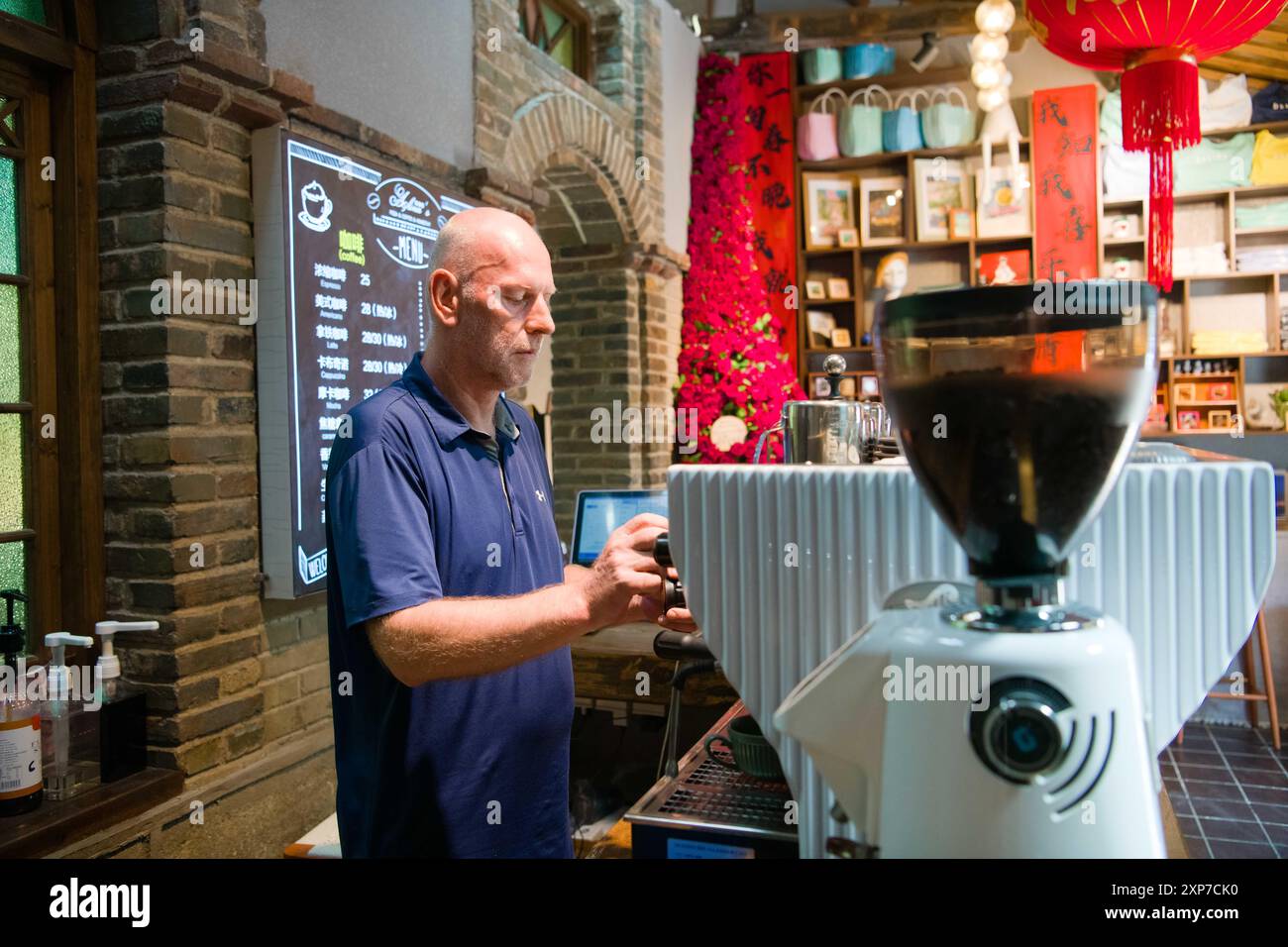 (240804) -- YIXIAN, 4. August 2024 (Xinhua) -- Armin Schober macht Kaffee in seinem Geschäft im Dorf Hongcun, County Yixian, Stadt Huangshan, ostchinesische Provinz Anhui, 31. Juli 2024. Armin ist ein österreichischer Geschäftsmann, der im Dorf Tachuan im County Yixian lebt. 2021 reiste Armin mit seiner Familie nach Tachuan, wo sie von der malerischen Landschaft und der unverwechselbaren lokalen Kultur angezogen wurden. Armin und seine chinesische Frau Huang Qiong beschlossen, sich mit ihrer Tochter Alina im Dorf niederzulassen und eine Gastfamilie zu übernehmen. Die Gastfamilie wurde nach Alina als „Alina's Garden“ benannt, was auf den Ex des Paares hindeutet Stockfoto