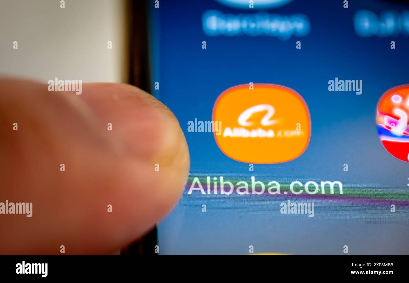 London. UK- 07.28.2024. Die chinesische multinationale E-Commerce-App Alibaba auf dem Bildschirm eines Android-Telefons und einem Finger, der die App öffnet Stockfoto