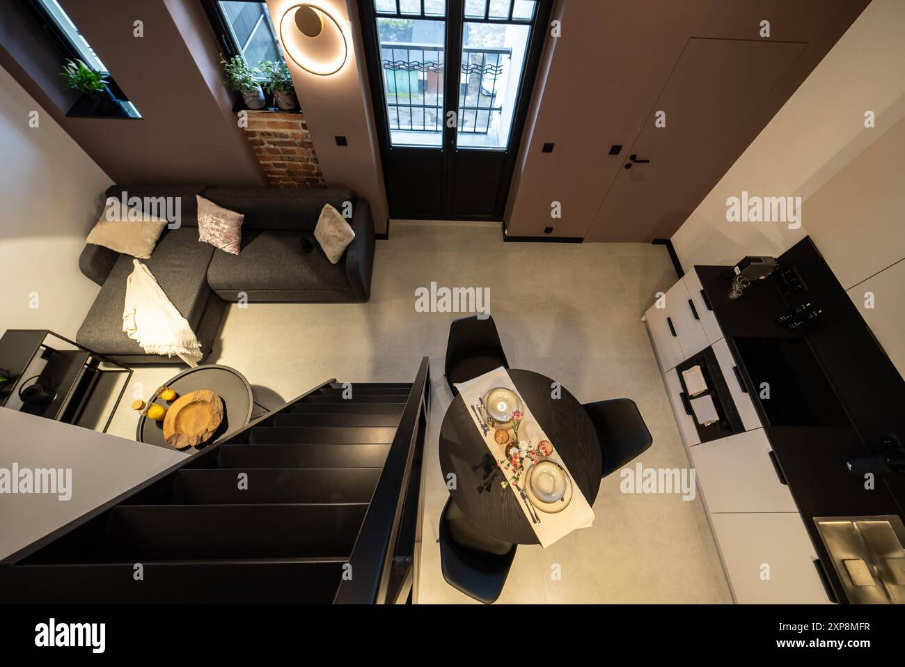 Modernes Studio-Apartment mit Zwischengeschoss-Schlafzimmer. Stilvolle Küche, die nahtlos mit einem gemütlichen Wohnzimmer verbunden ist, ideal für kleine Wohnräume. Klein und Mo Stockfoto