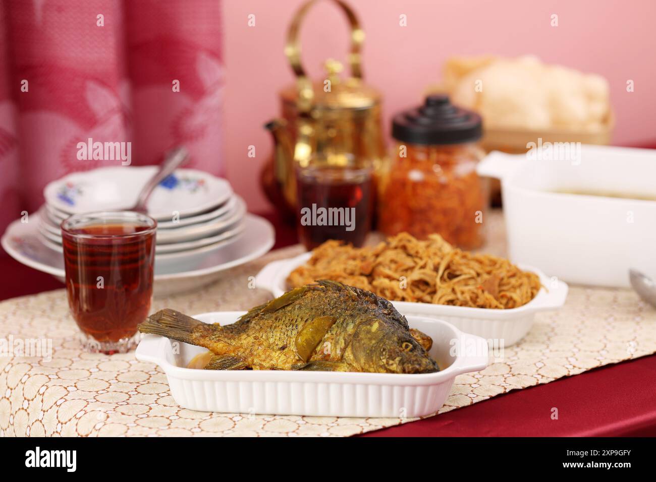 Ikan Goreng Nila Tilapia auf rotem Tisch, indonesischer Fisch Stockfoto