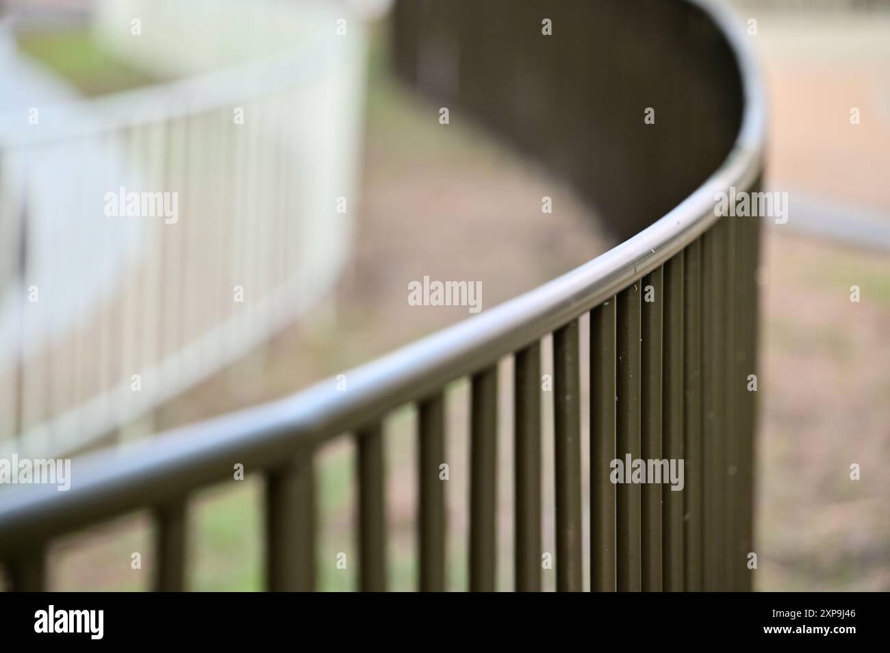 Präsentieren Sie ein geschwungenes Geländer in moderner Architektur, das die glatten Linien und die einzigartige optische Wirkung im Vergleich zu starren geraden Linien unterstreicht. Stockfoto