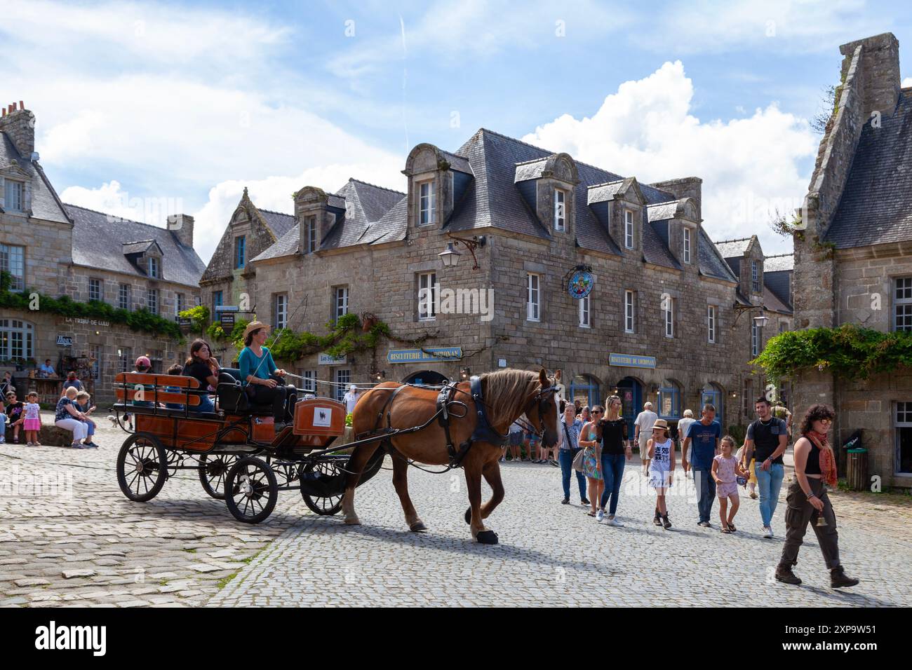 Locronan, Frankreich - 17. August 2023: Pferdekutsche bringt Touristen durch das Stadtzentrum. Stockfoto