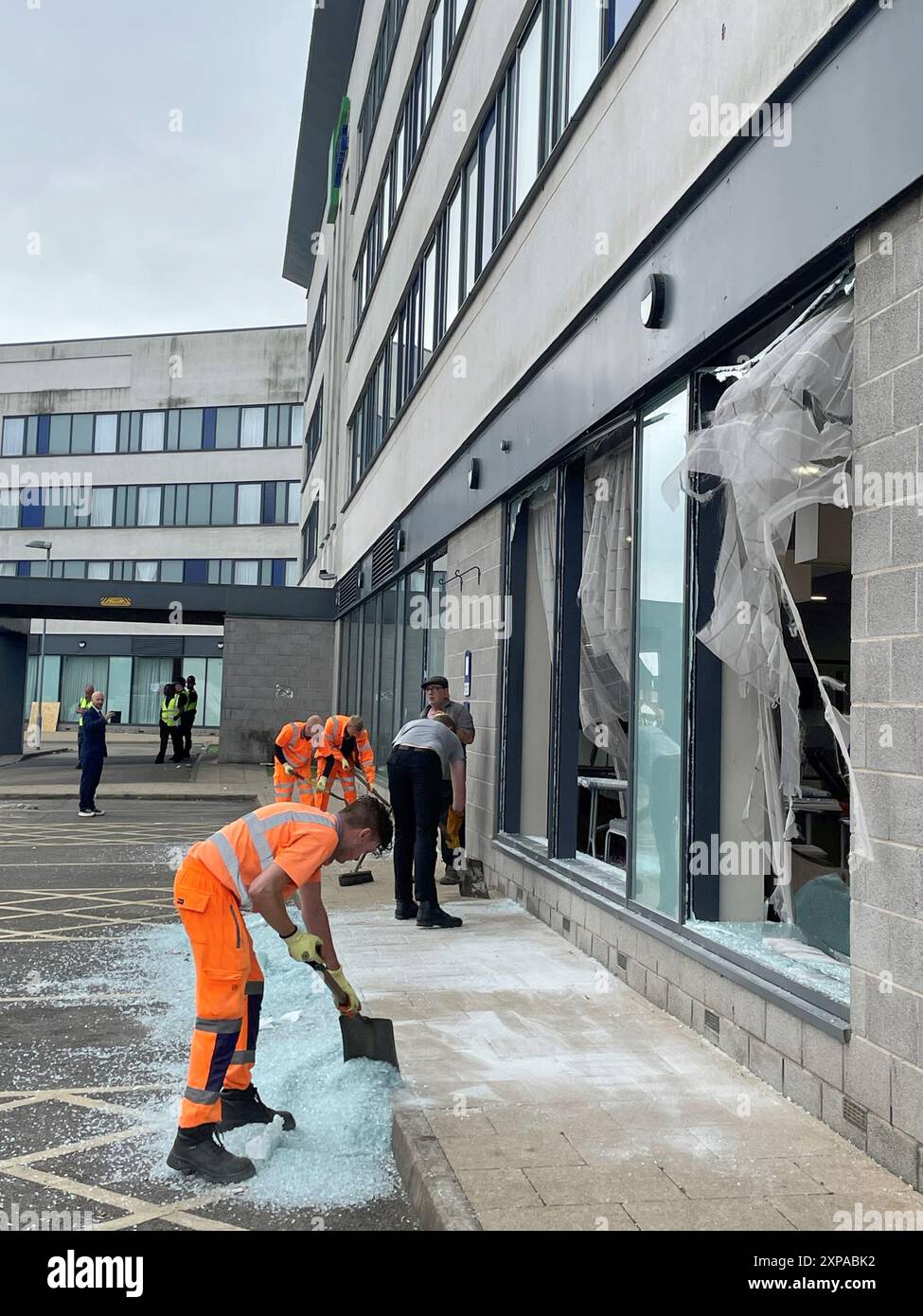 Im Holiday Inn Express in Rotherham, South Yorkshire, werden Trümmer beseitigt, wo Einwanderungsgegner am Sonntag die Fenster zertrümmerten, bevor sie Feuer auslösten. Mindestens 10 Polizisten wurden verletzt, darunter einer, der bewusstlos geschlagen wurde, bestätigte die Polizei von South Yorkshire später, dass eine Person bereits verhaftet worden sei und andere Beteiligte „erwarten sollten, dass wir sehr bald an ihrer Tür sind“. Bilddatum: Montag, 5. August 2024. Stockfoto