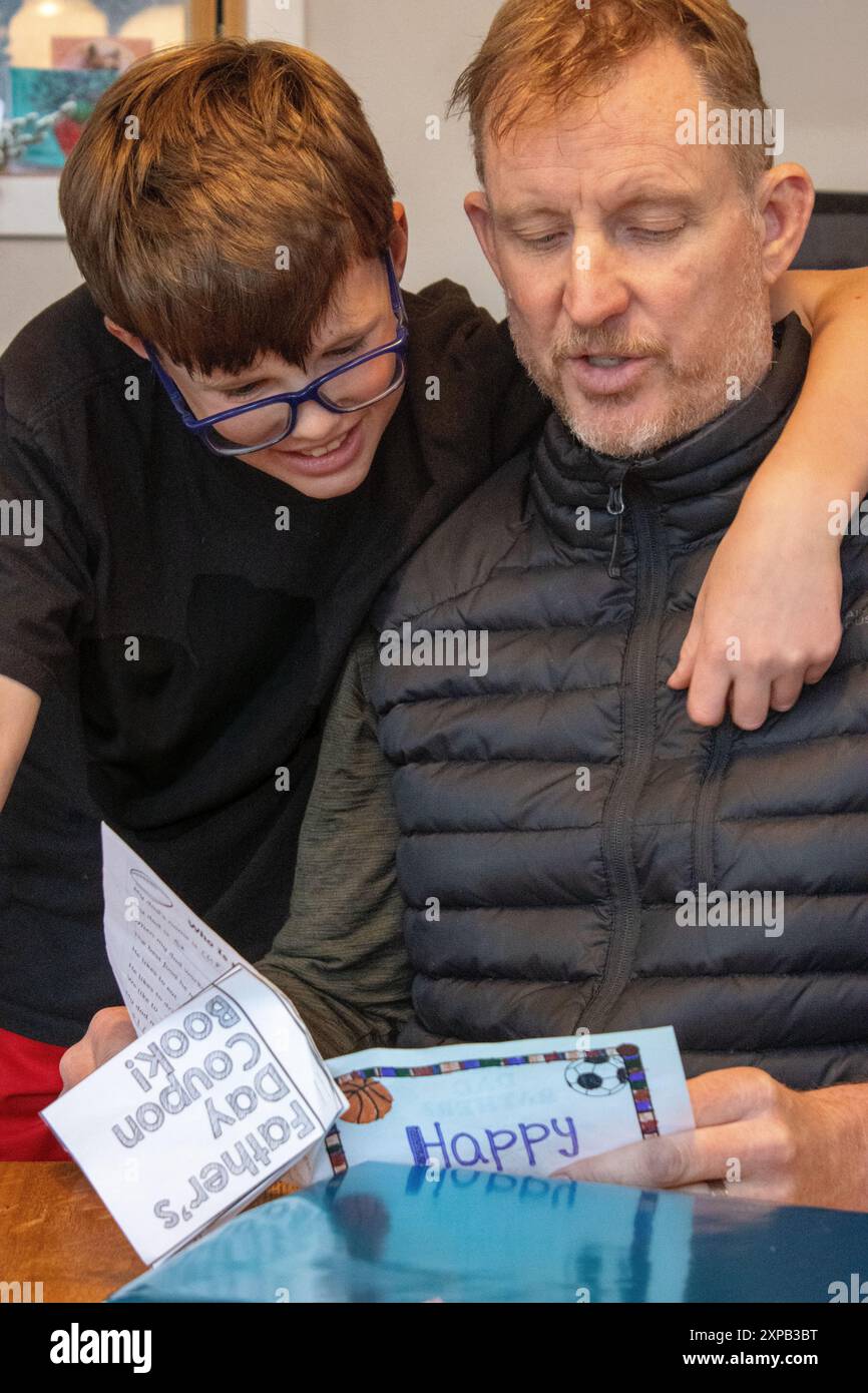 Vater und Sohn lesen zusammen eine handgefertigte Vatertagskarte Stockfoto