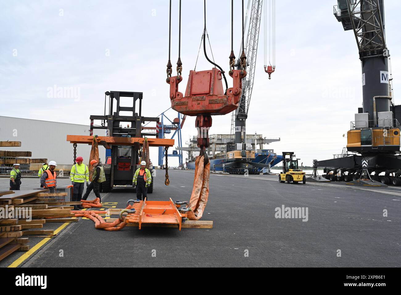 Bremse, Deutschland. August 2024. Hafenarbeiter unterbrechen die Arbeit beim Verladen. Als die Elektrolokomotiven spät am Hafen ankommen. Ab voraussichtlich 07.08.2024 um 6:00 Uhr sollen zwei strängige Elektrolokomotiven der Rail Cargo Carrier Germany GmbH (RCC) mit zwei Hafenmobilkranen auf den Lastkahn ELKA gebracht und auf dem Seeweg transportiert werden. Quelle: Lars Penning/dpa/Alamy Live News Stockfoto