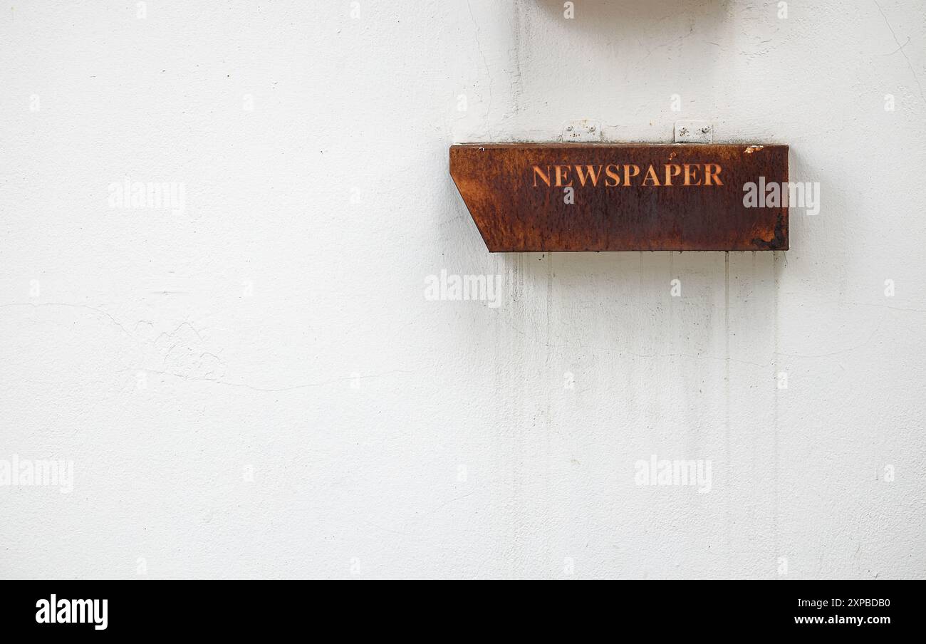 Alte Briefkasten oder Zeitungskiste aus Metall an der weißen Zementwand. Stockfoto