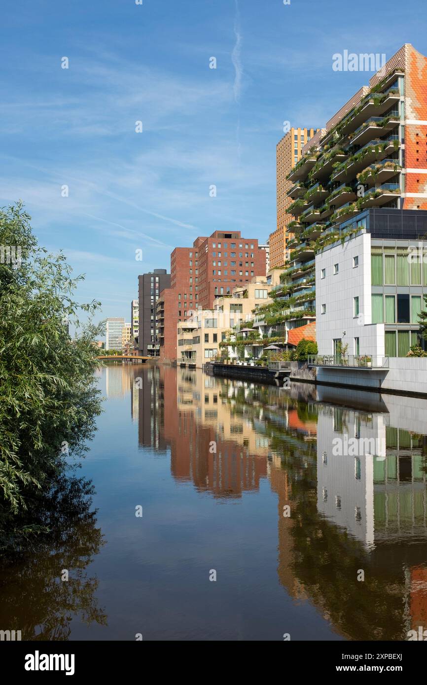 Moderne Hochhäuser mit gemischter Nutzung am Wasser im Stadtteil Zuidas in Amsterdam, Niederlande. Stockfoto