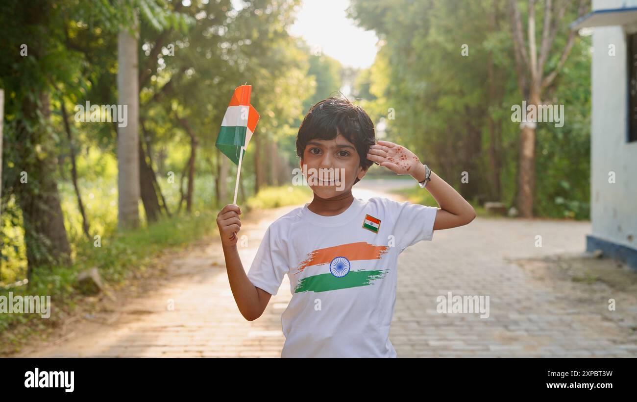 Kinder mit Familienmitgliedern tragen T-Shirt mit indischer Flagge und halten, winken oder laufen mit Tricolor mit Grün im Hintergrund, feiern Stockfoto
