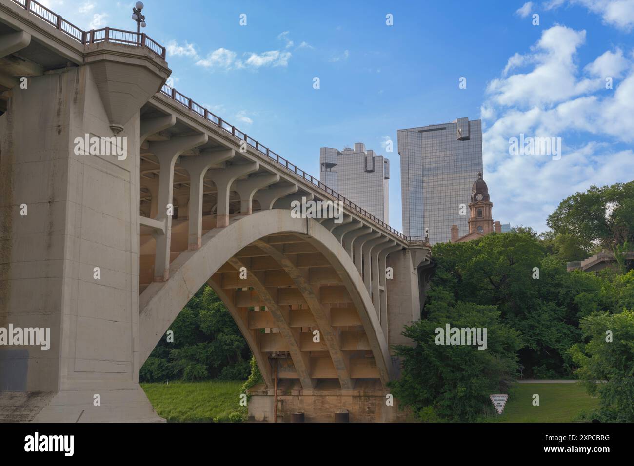 Main Street Bridge über den Trinity River im Zentrum von Fort Worth, Texas, USA mit dem alten Gerichtsgebäude von Tarrant County und zwei modernen Bürogebäuden. Stockfoto