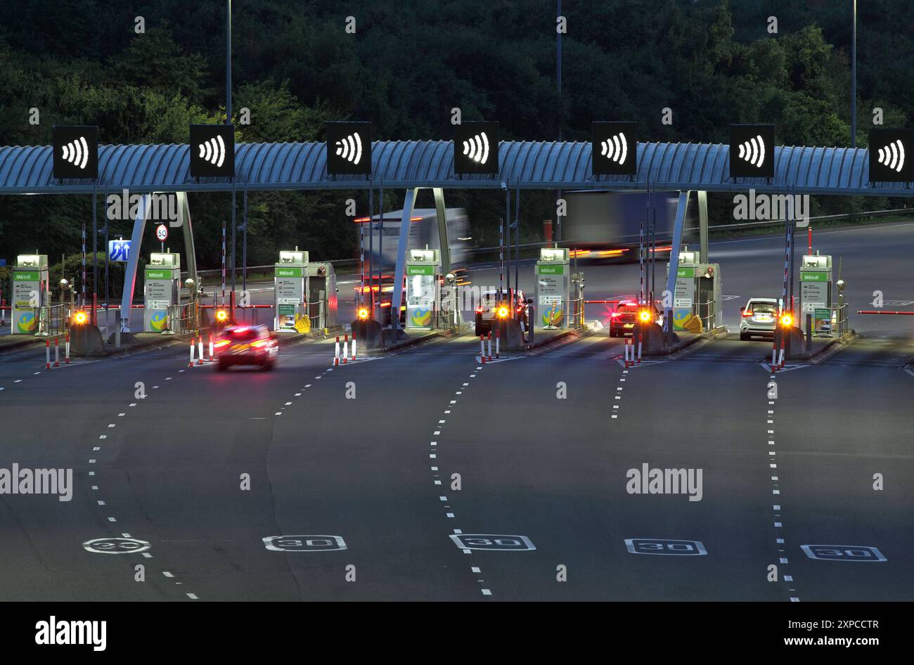 Mautstellen auf der M6 in nördlicher Richtung in der Nähe von Great Wyrley, Staffordshire, bei Nacht. Stockfoto