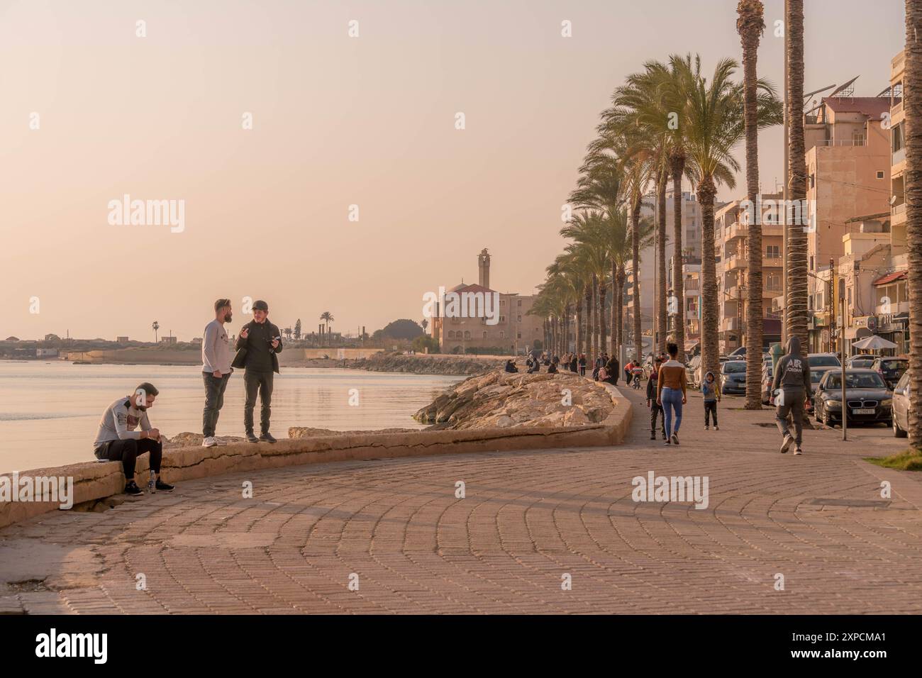 Die jungen Araber am Ufer von Tyrus mit den Palmen und der Promenade entlang des Mittelmeers, Libanon, Naher Osten. Stockfoto