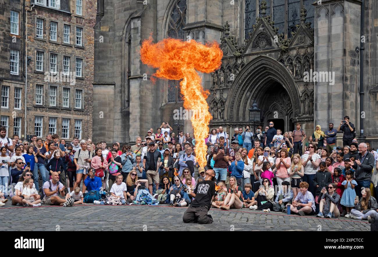 Edinburgh Festival Fringe erste Woche, Schottland, Großbritannien. 5. August 2024. Die Royal Mile ist sehr beschäftigt, aber nicht überfüllt mit Leuten, die auf der Suche nach Straßenauftritten der verschiedenen Acts sind, die aus der ganzen Welt reisen, um auf den Straßen der Hauptstadt aufzutreten. Im Bild: Chinnen aus Japan spielt mit Feuer auf dem Parlamentsplatz. Quelle: Arch White/Alamy Live News. Stockfoto