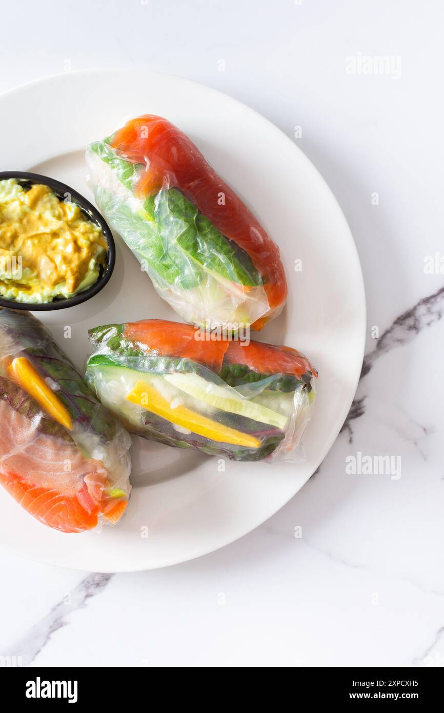 Genießen Sie den authentischen Geschmack vietnamesischer Frühlingsbrötchen mit Reispapier, frischem Gemüse, Lachs und Fischsauce, die das Beste aus asiatischem und thailändischem Cu vermischen Stockfoto