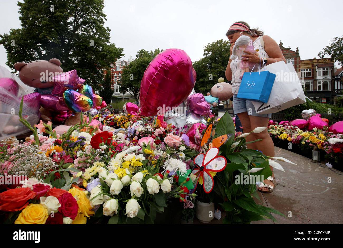 Mitglieder der Öffentlichkeit haben sich vor dem Rathaus in Southport vor einer Mahnwache die Blumen angeschaut, in Erinnerung an drei Kinder, die letzten Montag bei einem "wilden" Messerangriff während eines Taylor Swift-Events in einer Tanzschule starben. Bilddatum: Montag, 5. August 2024. Stockfoto