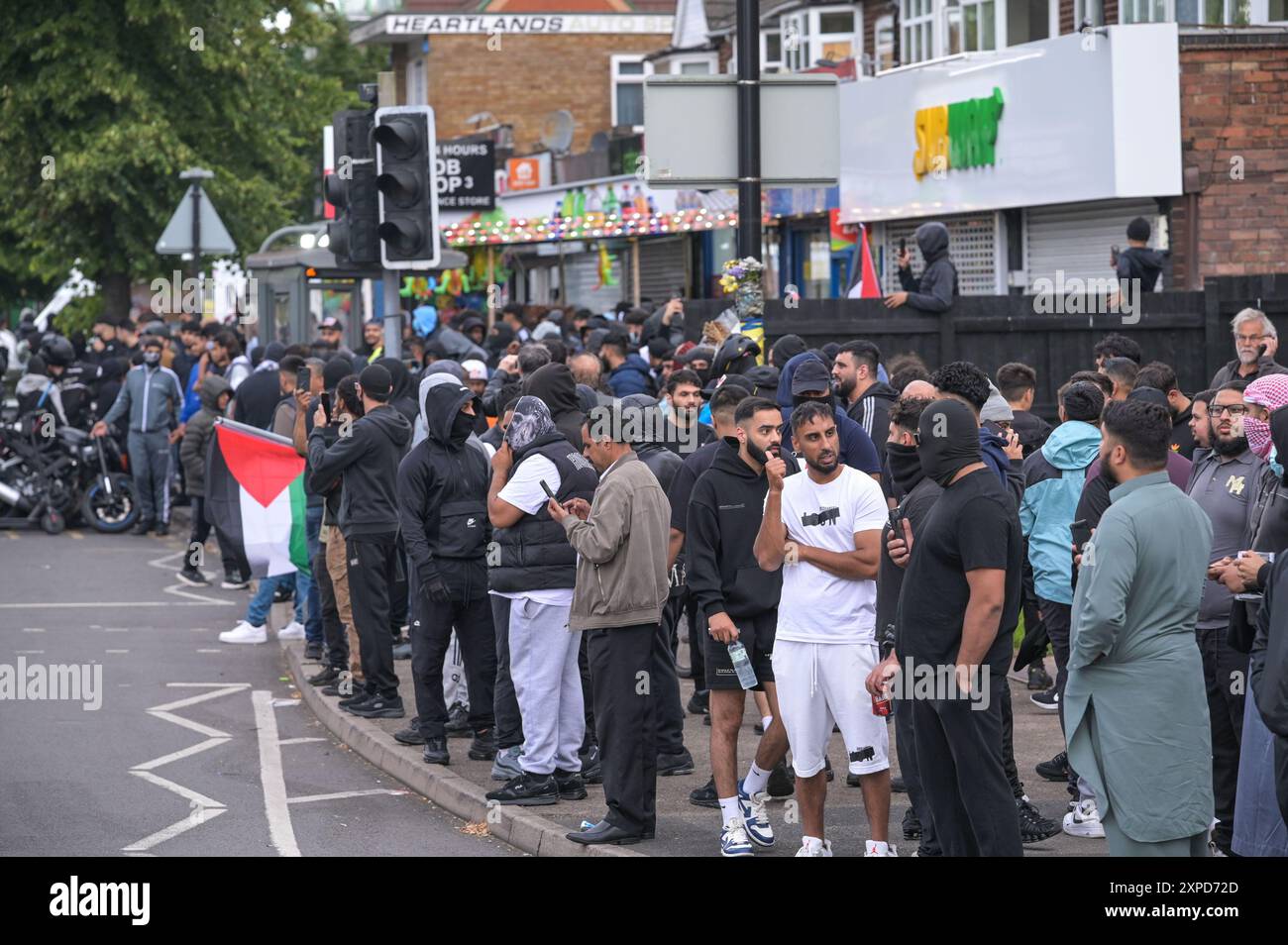 Bordesely Green, Birmingham 5. August 2024 - Hunderte von Menschen kamen heraus, um lokale Geschäfte und eine Moschee (Village Islamic Centre) zu schützen, nachdem Gerüchte über Mitglieder der EDL und andere Demonstranten in die Gegend kamen. Die Geschäfte wurden geschlossen und ein lokales Krankenhaus schickte das Personal nach Hause, da zu erwarten war, dass Gewalt bedroht war. Aufgrund der Reaktion der Komunionen kamen jedoch keine Patrioten an und die friedlichen Proteste setzten sich durch. ENDE - Guthaben: Stop Press Media/Alamy Live News Stockfoto