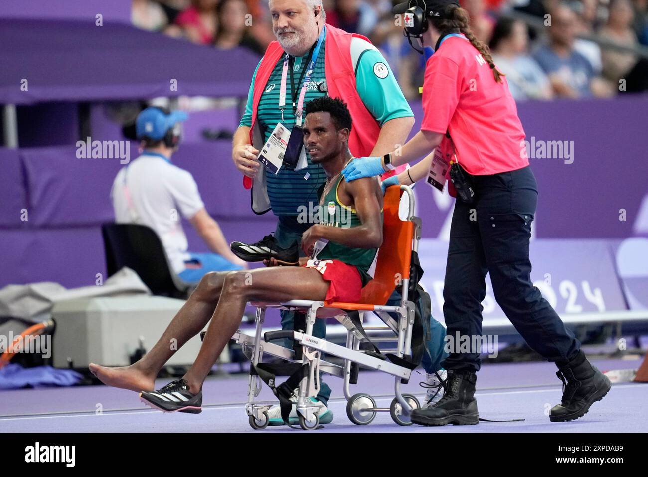Samuel Firewu, of Ethiopia, is wheeled out of the track after finishing