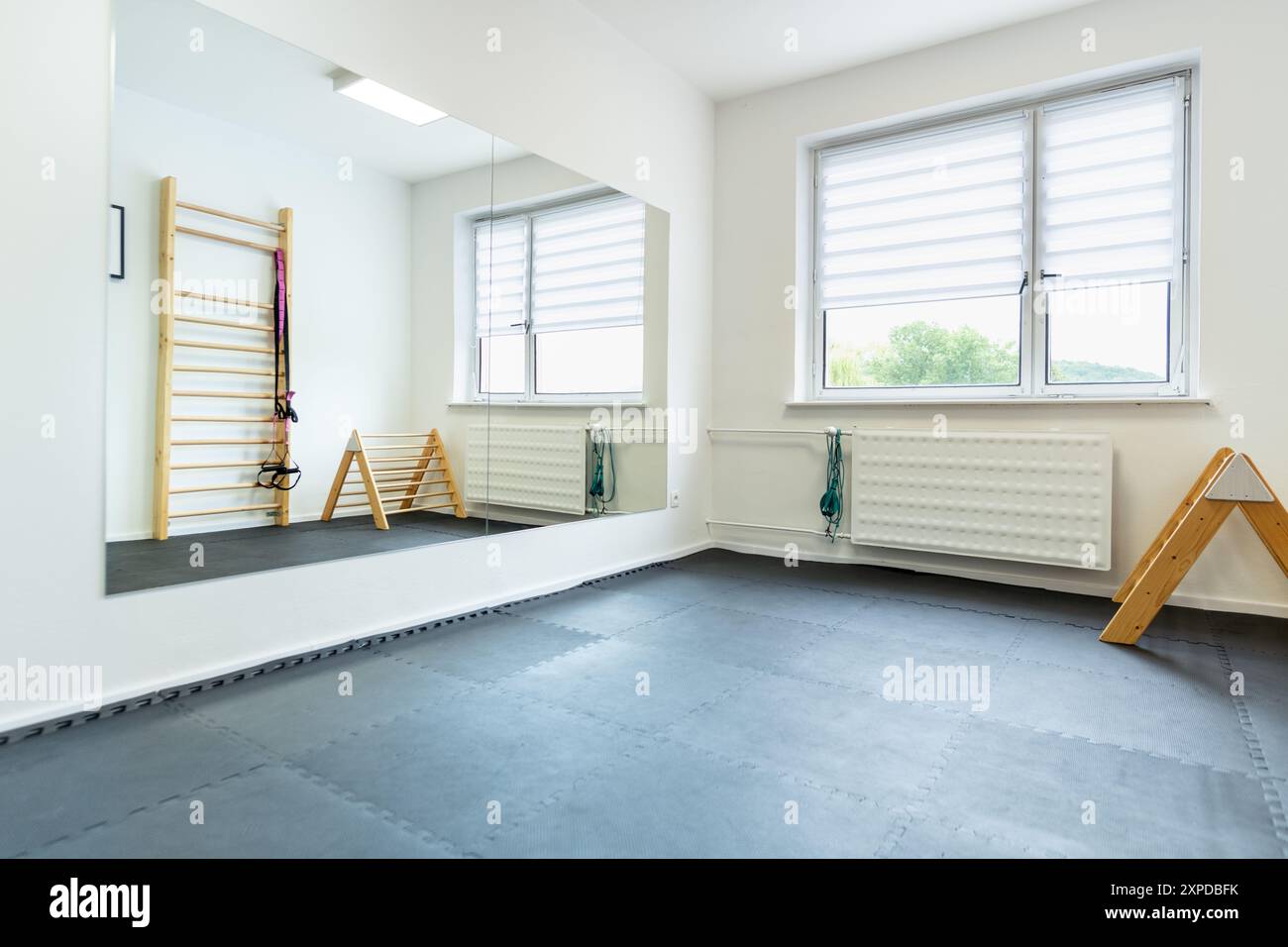 Leerer Physiotherapieraum mit hölzernen Übungsgeräten. Stockfoto