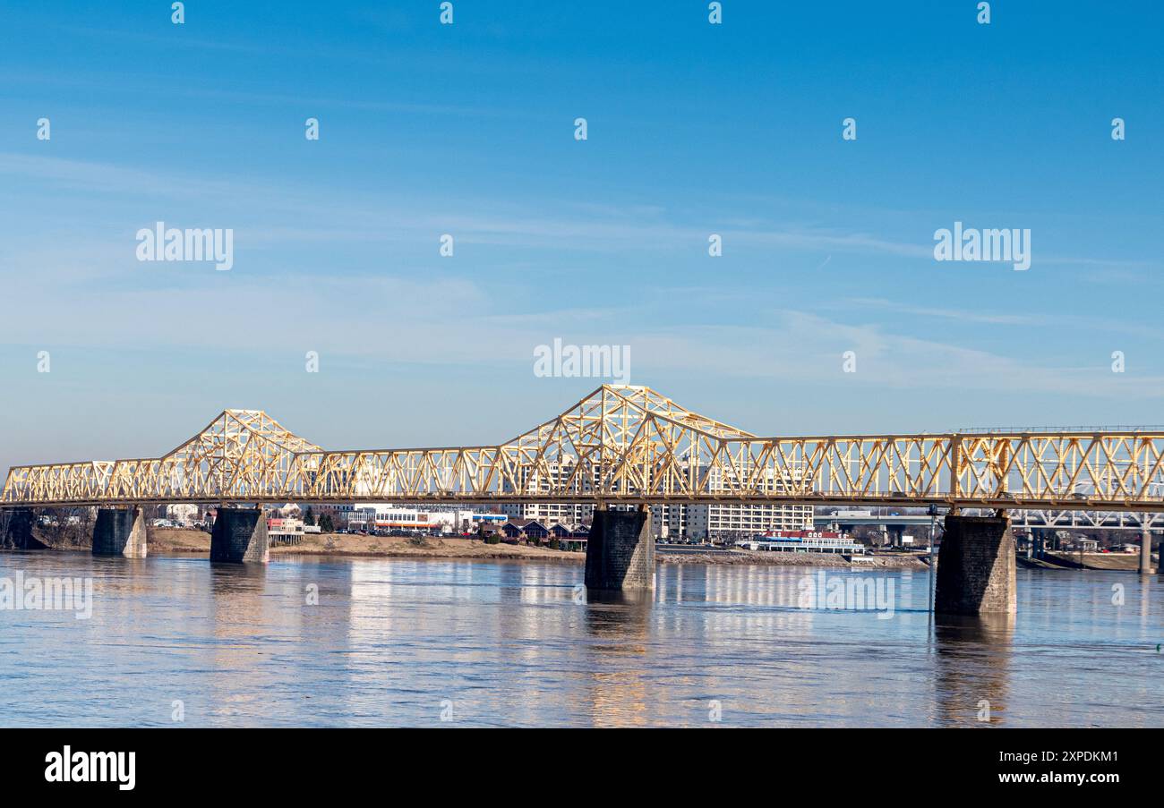 Stahlbalken-Fachwerkbrücke auf Steinpylonen über einem breiten Fluss Stockfoto