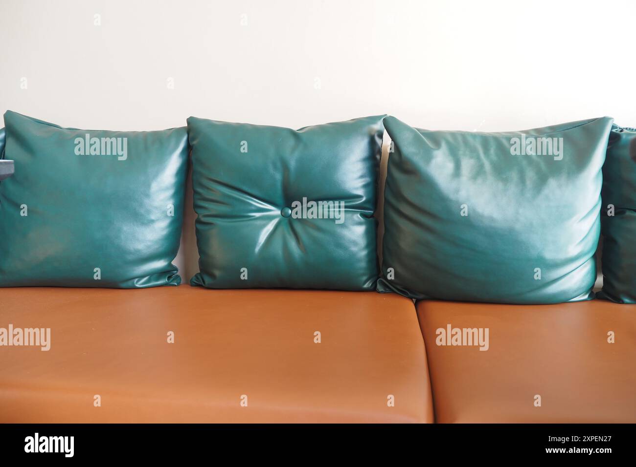 Stilvolle, elegante Lederpolster in Grün und Braun auf einem modernen Sofa Stockfoto