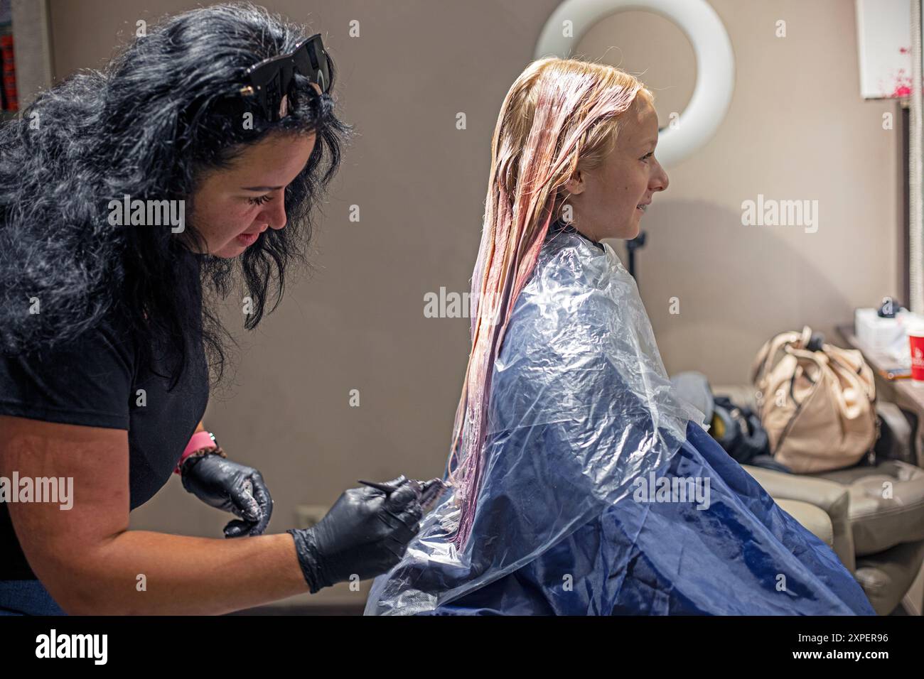 Schöne helle Färbung in hellen Rosa- und Violetönen auf hellen, langen Haaren. Modische Frisuren Stockfoto