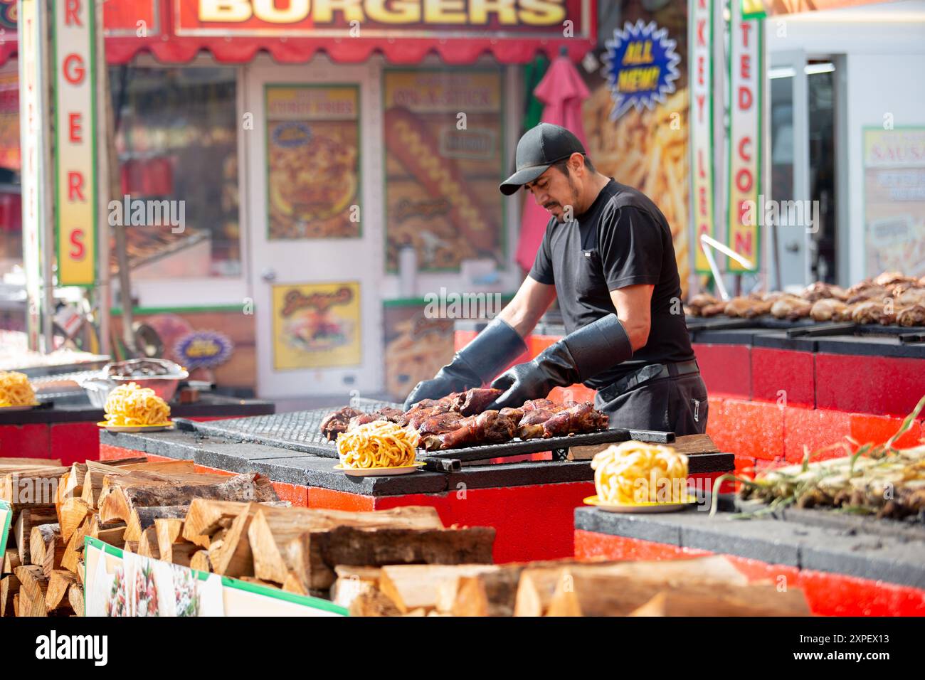 Puyallup, Washington, Vereinigte Staaten - 13. September 2021: Ein Blick auf einen Grubenmeister, der den Grill bei einem Lebensmittelhändler zubereitet, gesehen auf der Washington State Fair. Stockfoto