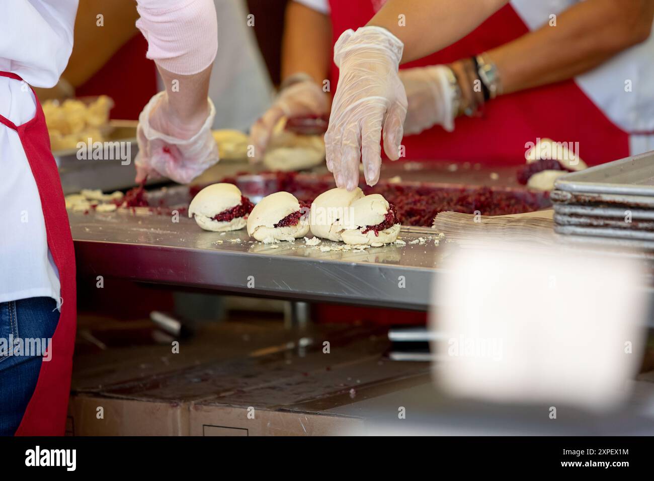 Ein Blick auf Mitarbeiter, die Scones mit Himbeermarmelade auf einer lokalen Messe in Puyallup, Washington, herstellen. Stockfoto