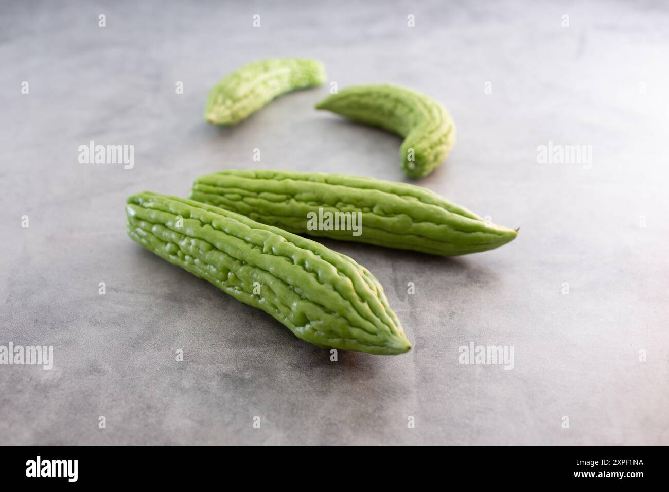 Eine Ansicht mehrerer Einheiten Bittermelonen, die auf einer Oberfläche verstreut sind. Stockfoto
