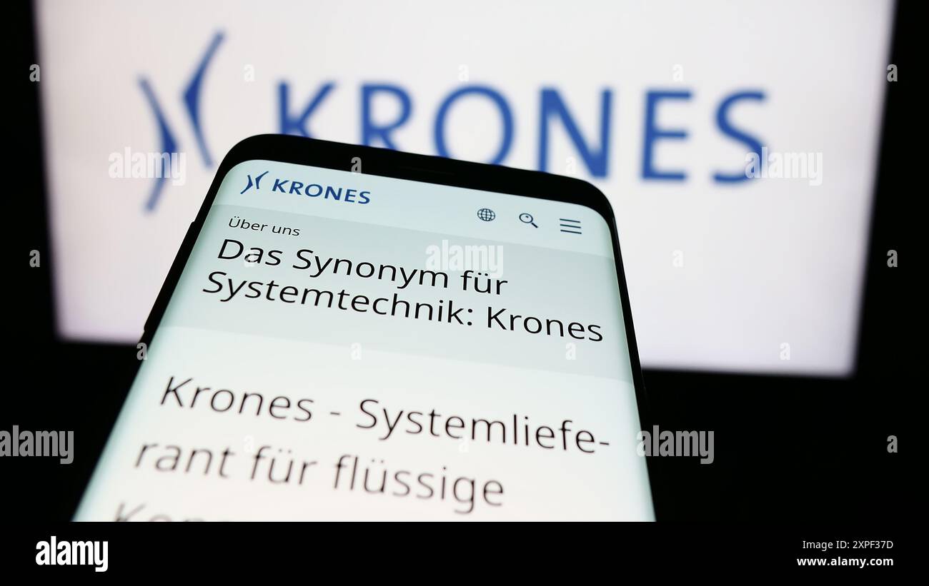 Mobiltelefon mit Website des deutschen Maschinenbauunternehmens Krones AG vor dem Firmenlogo. Fokussieren Sie sich oben links auf der Telefonanzeige. Stockfoto