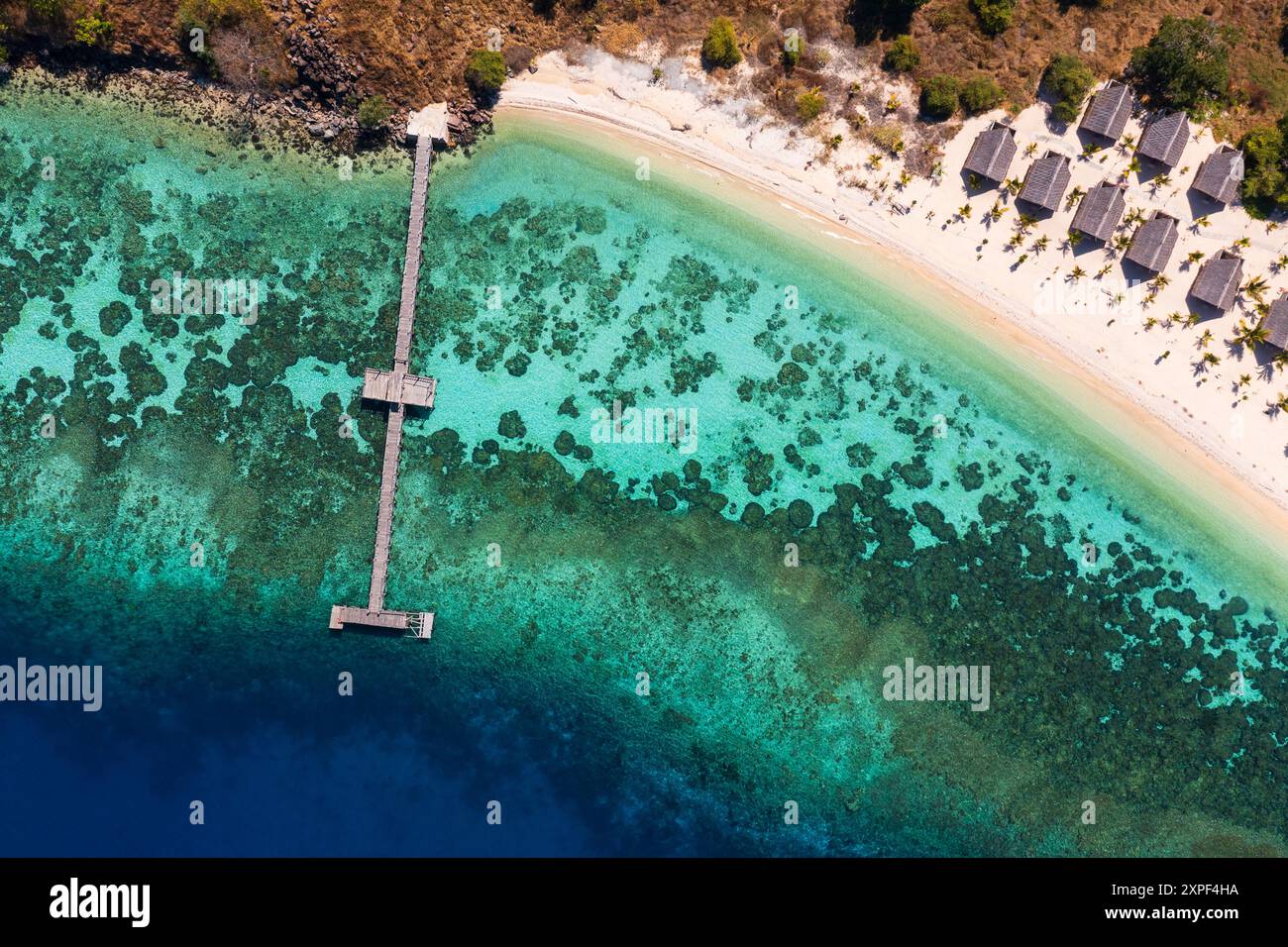 Labuan Bajo, Indonesien: Aus der Vogelperspektive auf eine idyllische Insel mit ihrem Steg vor dem Korallenriff in Flores in Labuan Bajo im Komodo-Gebiet in Ind Stockfoto