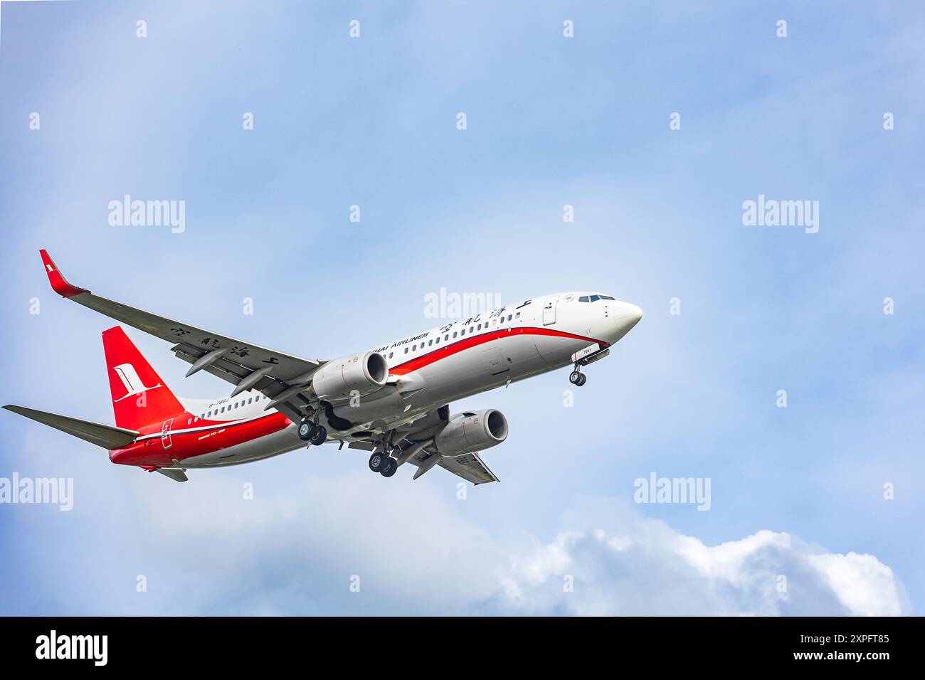 Shanghai Airlines. Boeing fliegt in der Luft mit Wolken im Hintergrund. Reisefoto, Kopierraum. Luftbus. Bei der Landung mit ausgefahrenen Rädern. Thailand Phuket Stockfoto