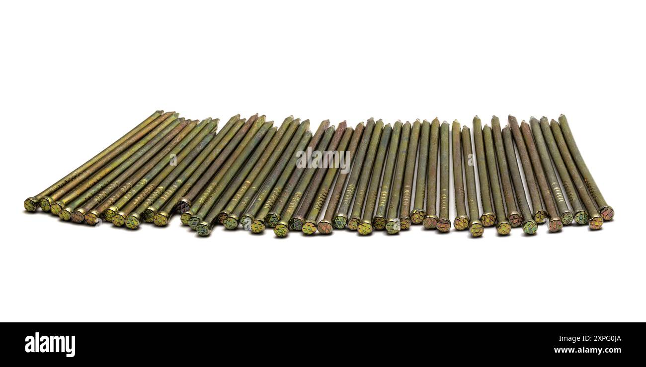 Goldene scharfe dünne Metallnägel in einer Reihe auf weißem Hintergrund gelegt, Nahaufnahme Makro Stockfoto