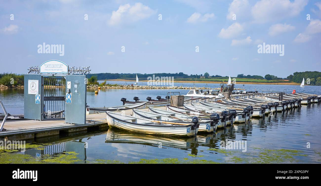 Ruder- und Motorboote (von Fischern verwendet), die in einem kleinen Hafen in einem englischen Wasserpark in Rutland, England, vor Anker liegen. Stockfoto