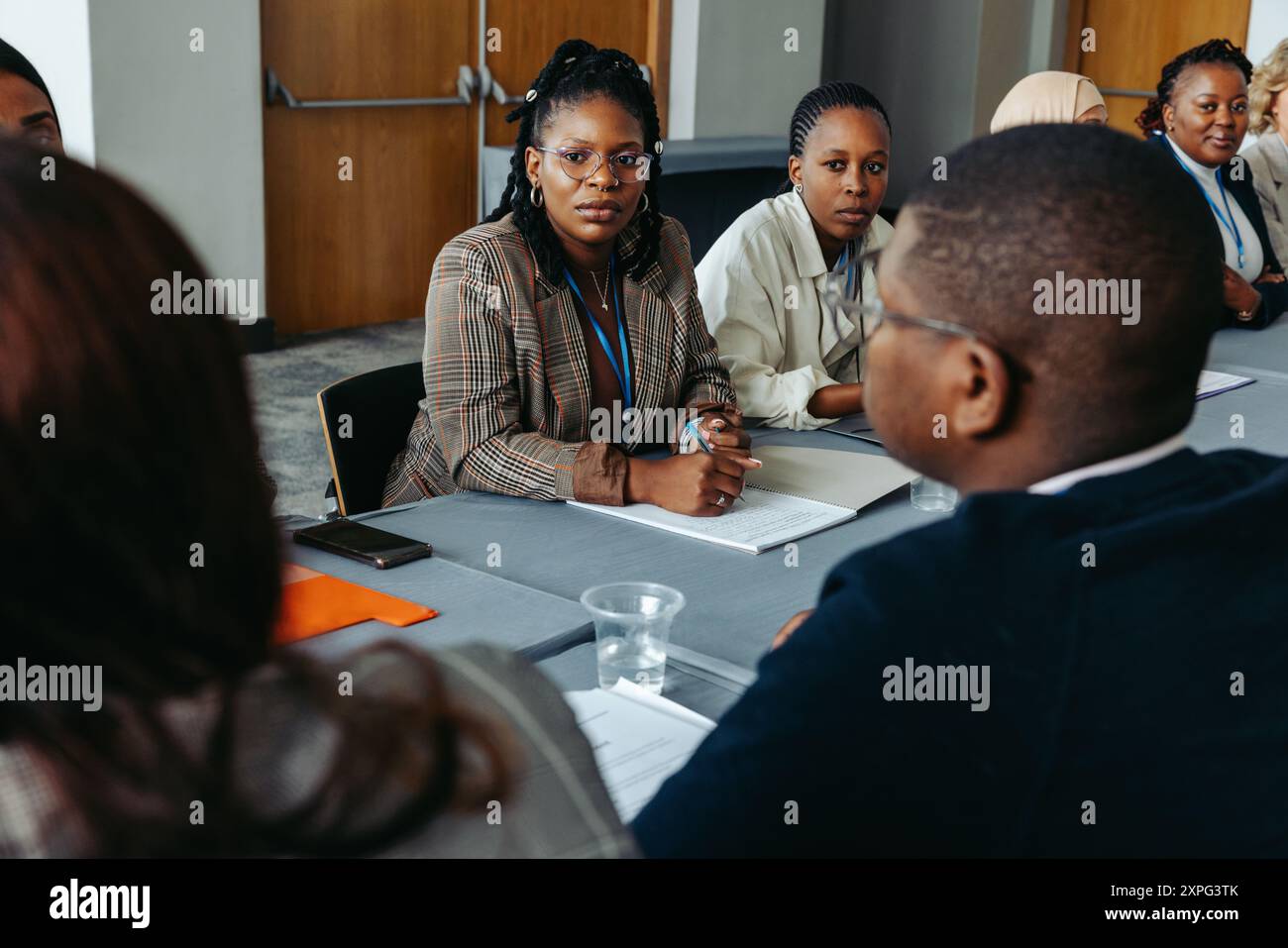 Verschiedene Kollegen nahmen an einer Diskussion in einem Konferenzraum Teil, in der Teamarbeit und Zusammenarbeit vorgestellt wurden. Ideal für Geschäfts-, Büro- und Firmenkunden Stockfoto