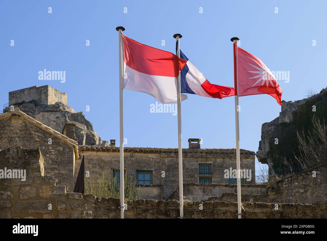 Les Baux-de-Provence, Frankreich - 4. März 2023: Flaggen in Les Baux de Provence an einem sonnigen Tag im Frühling, Place Prince Rainier III de Monaco Stockfoto