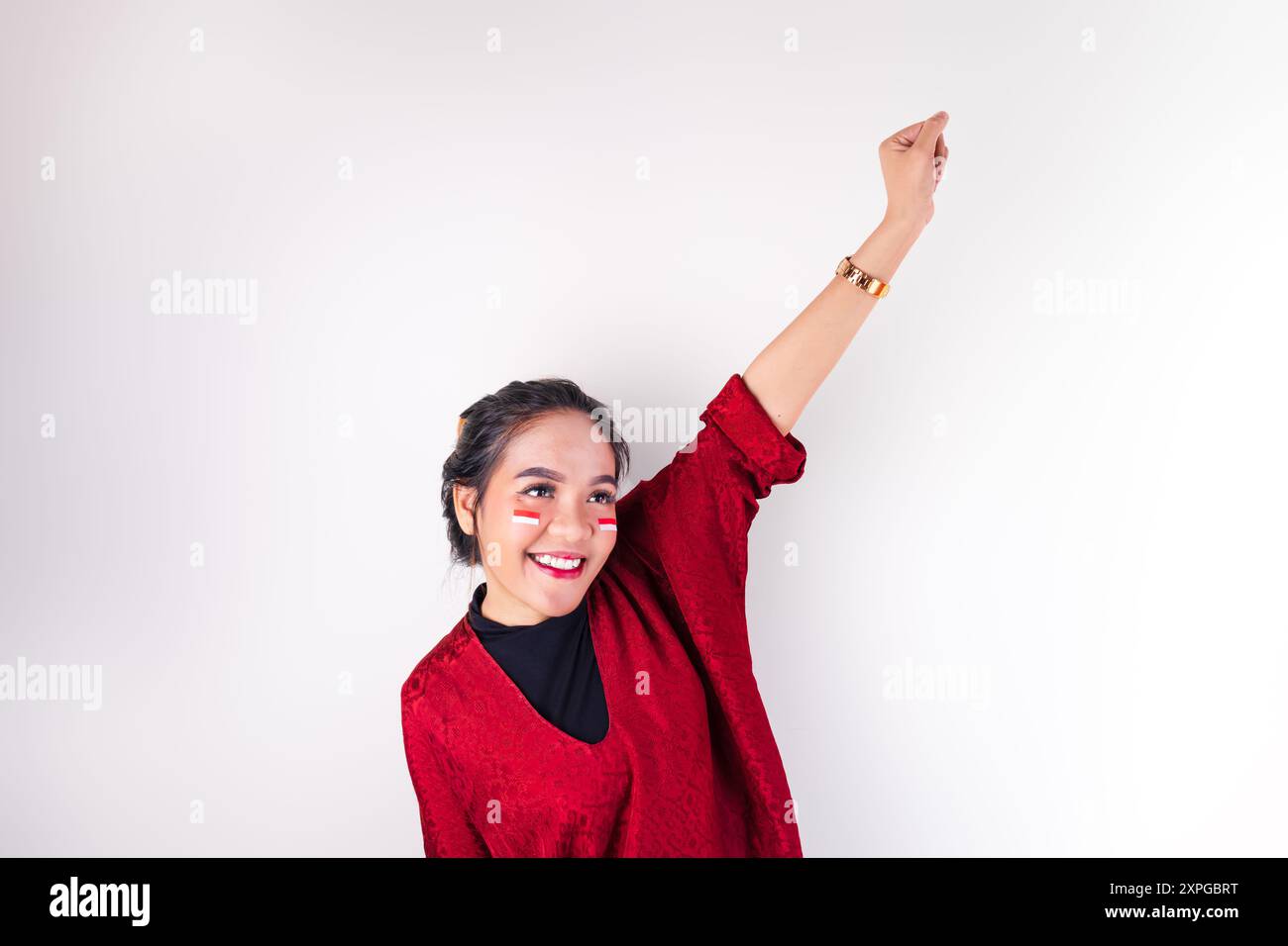 Eine asiatische Frau in rotem Kleid gibt ihren Ausdruck für den indonesischen Unabhängigkeitstag aus. Stockfoto