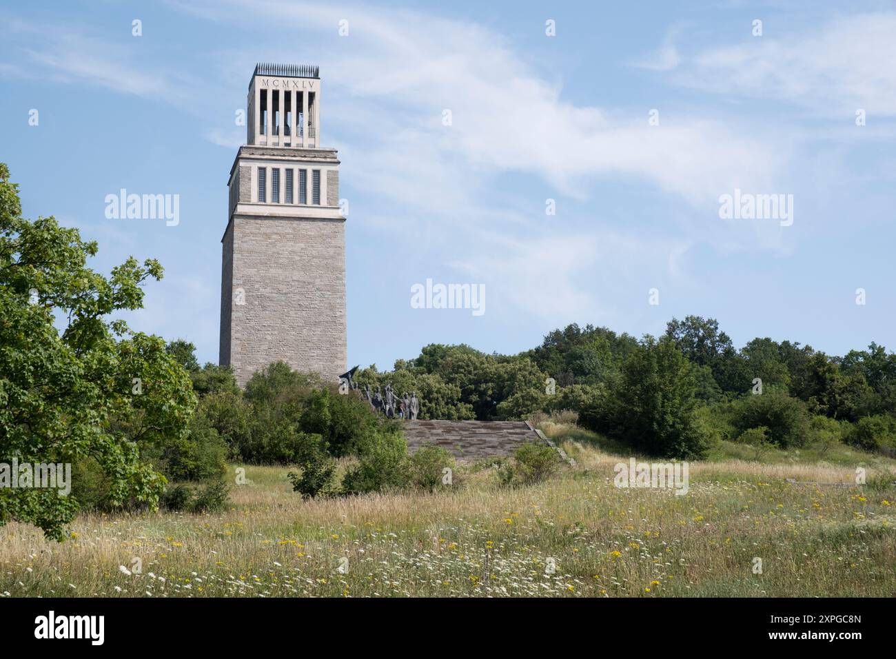 Der 50 Meter hohe Glockenturm auf dem Freiheitsplatz ist das größte Denkmal an ein Nazi-Konzentrationslager in Europa. Bronzestatue im Vordergrund Stockfoto