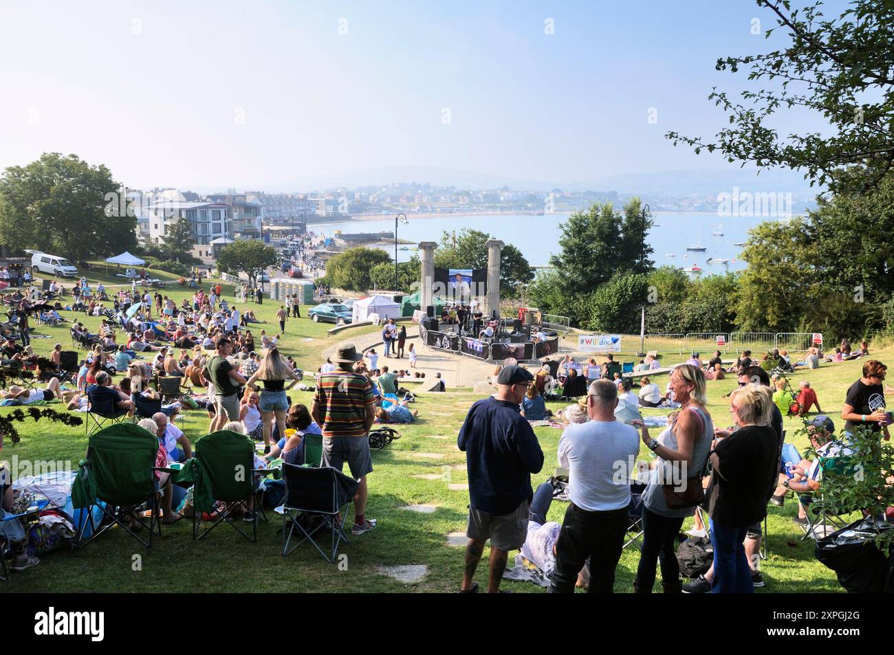 In Prince Albert Gardens mit Blick auf die Swanage Bay versammelten sich viele Menschen, um die Sonne zu genießen und die Indie-Rock-Band Galaxy Thief, Dorset, England, zu beobachten Stockfoto