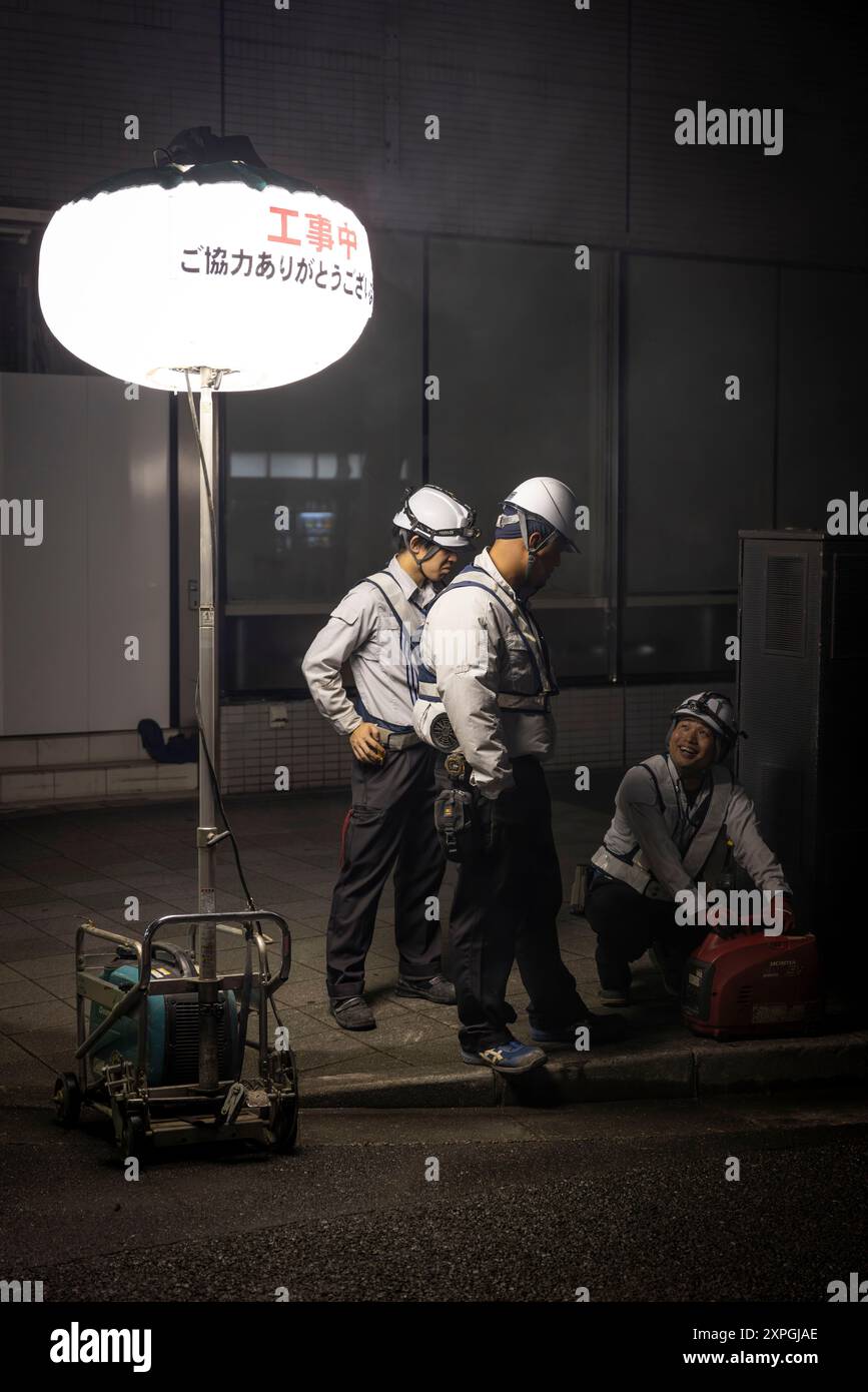 Tokio, Japan. August 2024. Japanische Bauarbeiter bauen nachts eine Straßenbaustelle auf. Neben den farbenfrohen, lebhaften und immer geschäftigen touristischen Hotspots wie Shibuya und Shinjuku bietet Tokio auch ruhigere und authentischere Gegenden, in denen Touristen lokale Küche genießen und echte Erfahrungen mit den Einheimischen machen können. Ein Beispiel für einen solchen Ort ist der alte Tsukiji Fischmarkt in der Nähe von Ginza. (Foto: Stanislav Kogiku/SOPA Images/SIPA USA) Credit: SIPA USA/Alamy Live News Stockfoto