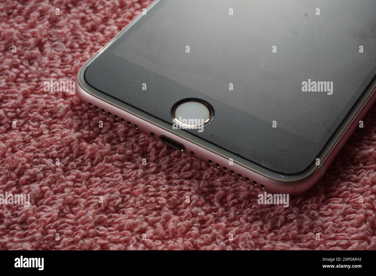 Nahaufnahme des Fingerabdrucksensors von Apple iphone 7 auf rotem Hintergrund. iphone 7 auf der Vorderseite. Stockfoto