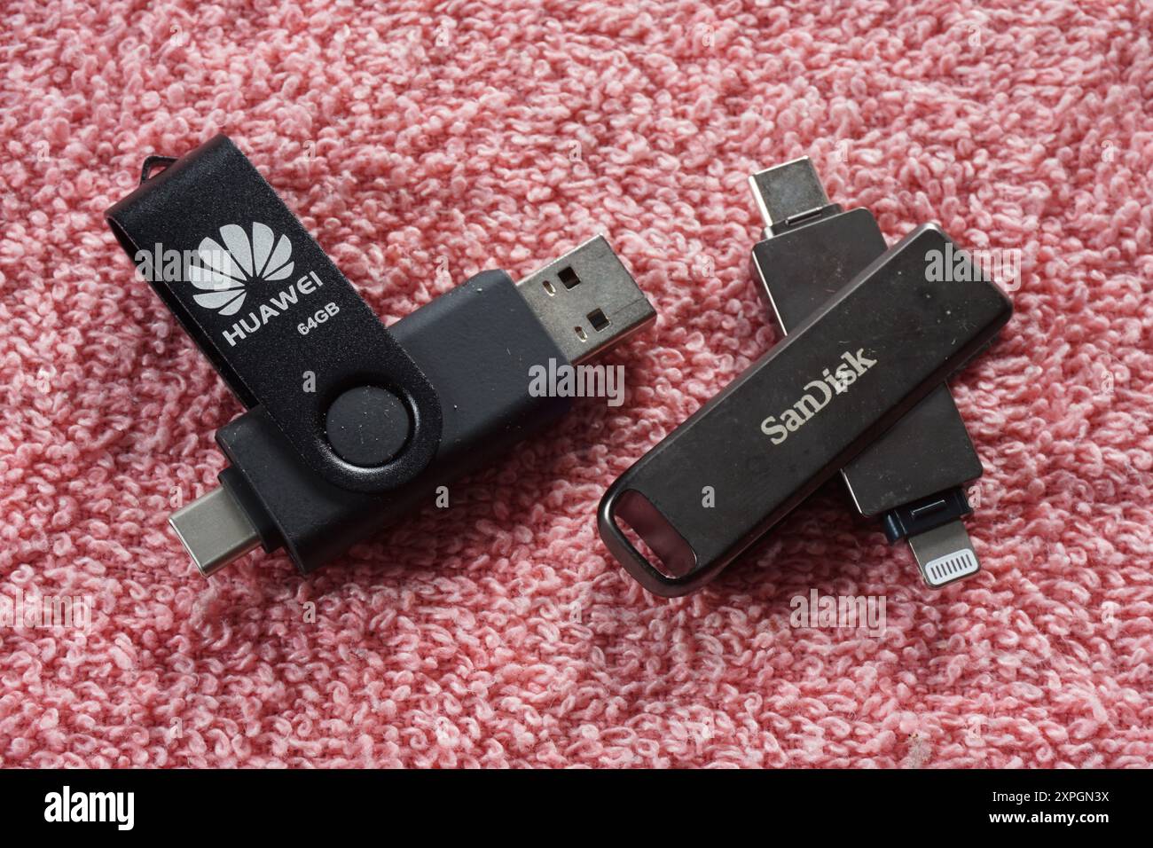 Terengganu, Malaysia - 24. August 2024 : Nahaufnahme von sandisk otg Dual Drive und huawei otg Dual Drive auf rotem Hintergrund Stockfoto