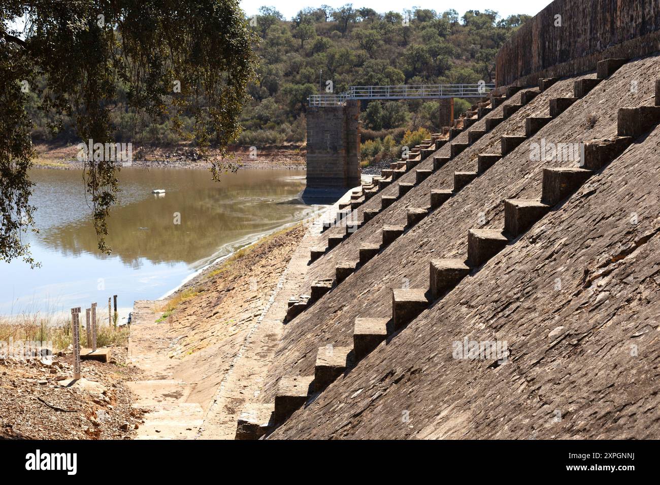 Wand eines Stausees, es gibt ein paar Treppen und einen Wassertiefenmarker. Die Wasserknappheit aufgrund von Dürre ist offensichtlich. Naturpark Cornalvo, Spanien Stockfoto