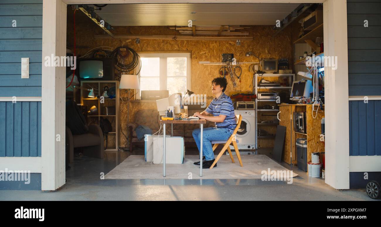 Kaukasischer Männlicher Software-Engineer, Der In Die Retro-Garage Einsteigt Und Mit Dem Alten Desktop-Computer An Seinem Schreibtisch Sitzt. Fokussierter Mann Gründet Software Startup Company In Den 90Er Jahren, Arbeitet An Digital Product. Stockfoto