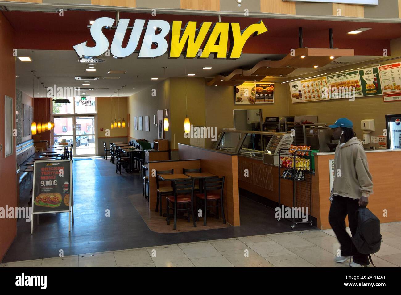 U-Bahn ist eine 1965 von Fred DeLuca und Peter Buck gegründete US-amerikanische Franchisekette im Fast-Food-Bereich. Die Produktpalette umfasst in erster Linie Sandwiches, Wraps und Salate. Die Sandwiches werden einzeln auf Bestellung in Sichtweite zubereitet. Seit Ende 2010 ist Subway die Fastfoodkette mit den weltweit meisten Restaurants. Im deutschsprachigen Raum ist Subway seit Ende der 1990er Jahre vertreten. Im August 2023 wurde Subway an den Finanzinvestor Roark Capital verkauft. Foto: Subway Fastfood - Restaurant in einem Einkaufscenter *** Subway ist eine US-amerikanische Fastfood-Franchise-Kette Stockfoto