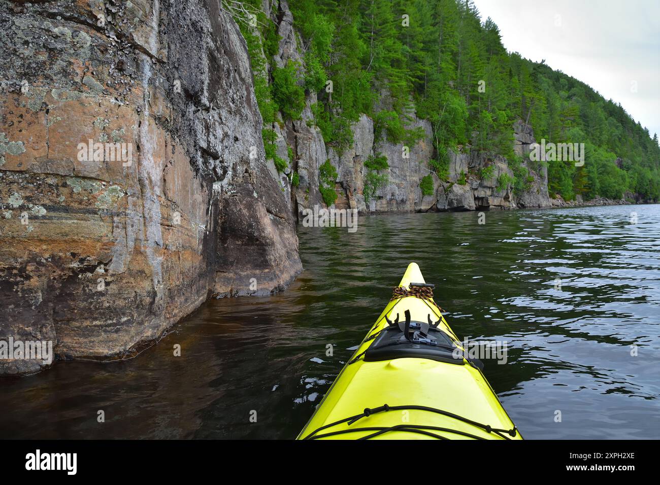 Gelbes Seekajak auf einem See mit Felsenwand. Wapizagonke Lake Canada Park La Mauricie, Quebec, Kanada. Ruhiger Tag zum Paddeln. Stockfoto