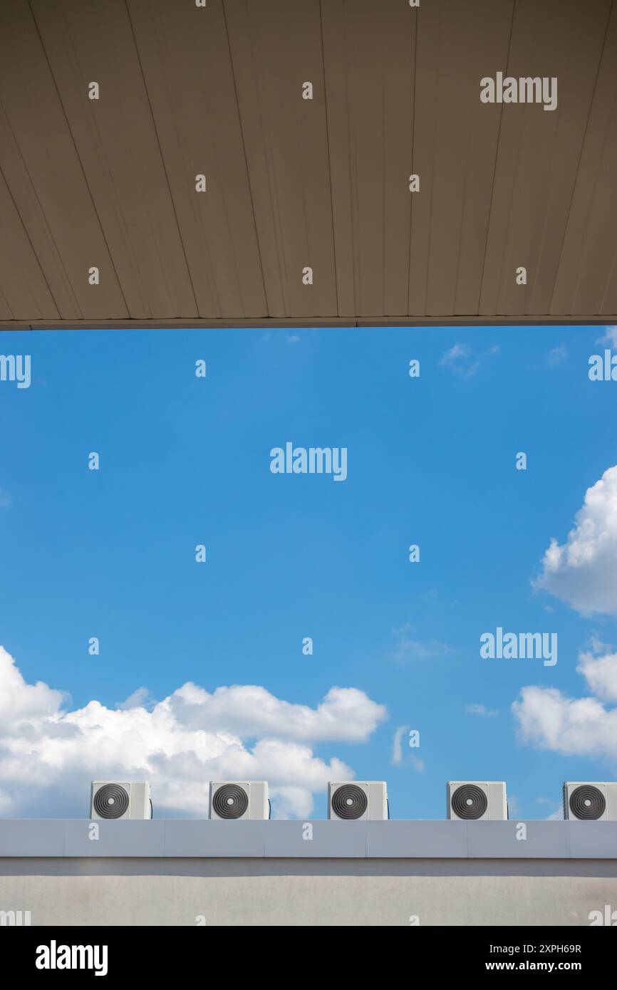 Mehrere Ventilatoren einer Klimaanlage auf dem Dach eines Gebäudes vor blauem Himmel. Das Foto wurde an einem sonnigen Tag gemacht. Stockfoto Mehrere Ventilatoren einer Klimaanlage auf dem Dach eines Gebäudes vor blauem Himmel. Das Foto wurde an einem sonnigen Tag gemacht. Stockfoto