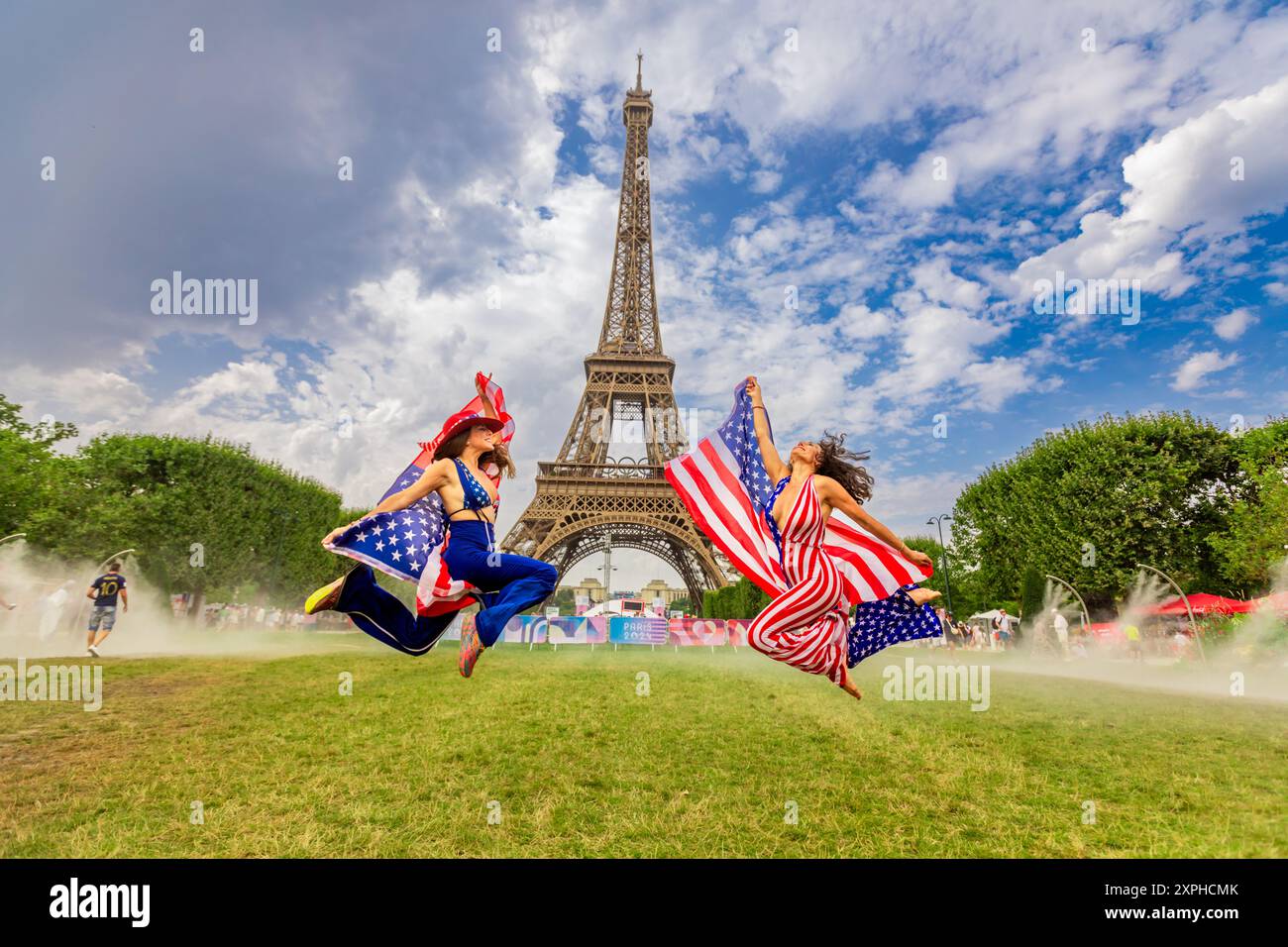 Patriotische Amerikanerin springt und jubelt für das Team USA und die Olympischen Spiele 2024 in Paris vor dem Eiffelturm, Paris, Frankreich, Europa Stockfoto