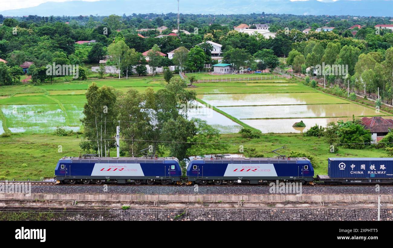 Vientiane, chinesische Provinz Yunnan. August 2024. Auf diesem Drohnenfoto verlässt ein voll beladener Zug, der unabhängig von einem laotischen Zugführer gefahren wird, den Bahnhof Vientiane in Vientiane, Laos, und fährt am 5. August 2024 nach Kunming, südwestchinesischer Provinz Yunnan. Die erste Gruppe von Laotischen Zugführern, die selbständig auf der China-Laos-Bahn arbeiten, erhielt nach einer Qualifikationsausbildung förmlich Führerscheine. Quelle: Yang Yongquan/Xinhua/Alamy Live News Stockfoto