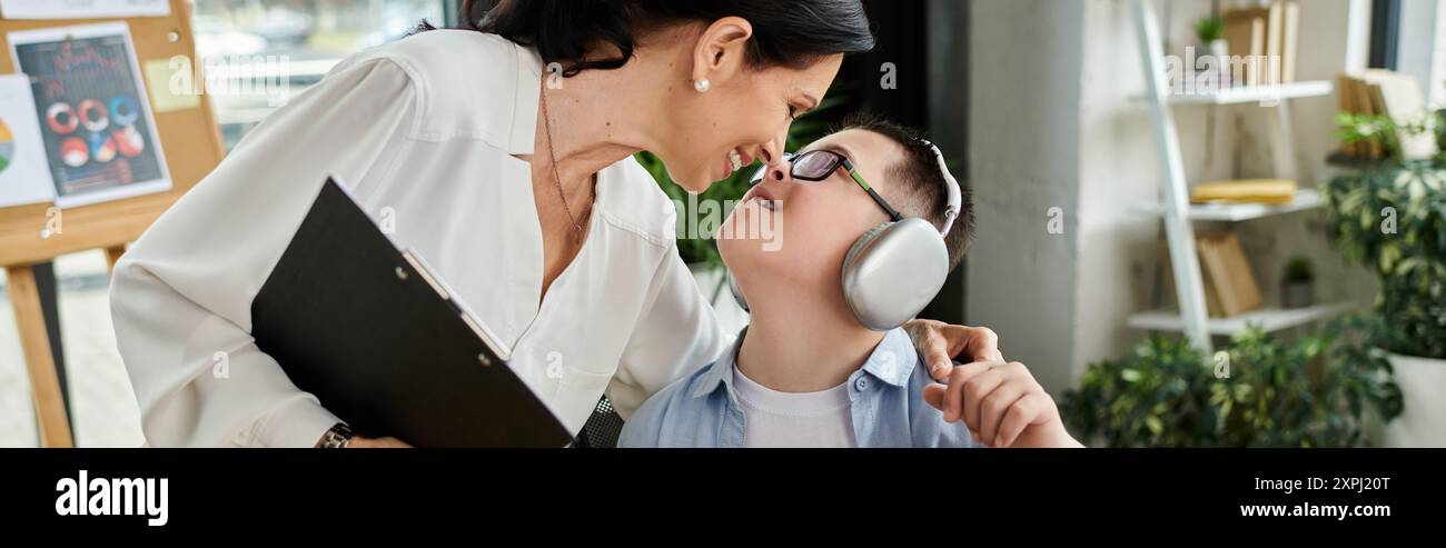 Berufstätige Mutter liebt Vielfalt, indem sie sich mit einem Sohn verbindet, der ein Down-Syndrom hat, und hebt die Inklusivität am Arbeitsplatz hervor. Stockfoto