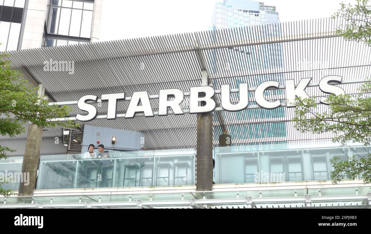 Hongkong, China. August 2024. Ein Paar, das unter dem starbucks-Logo des Kaffeehauses in Hongkong, China (Credit Image: © Serene Lee/SOPA Images via ZUMA Press Wire) gesehen wurde, WIRD NUR REDAKTIONELL VERWENDET! Nicht für kommerzielle ZWECKE! Stockfoto
