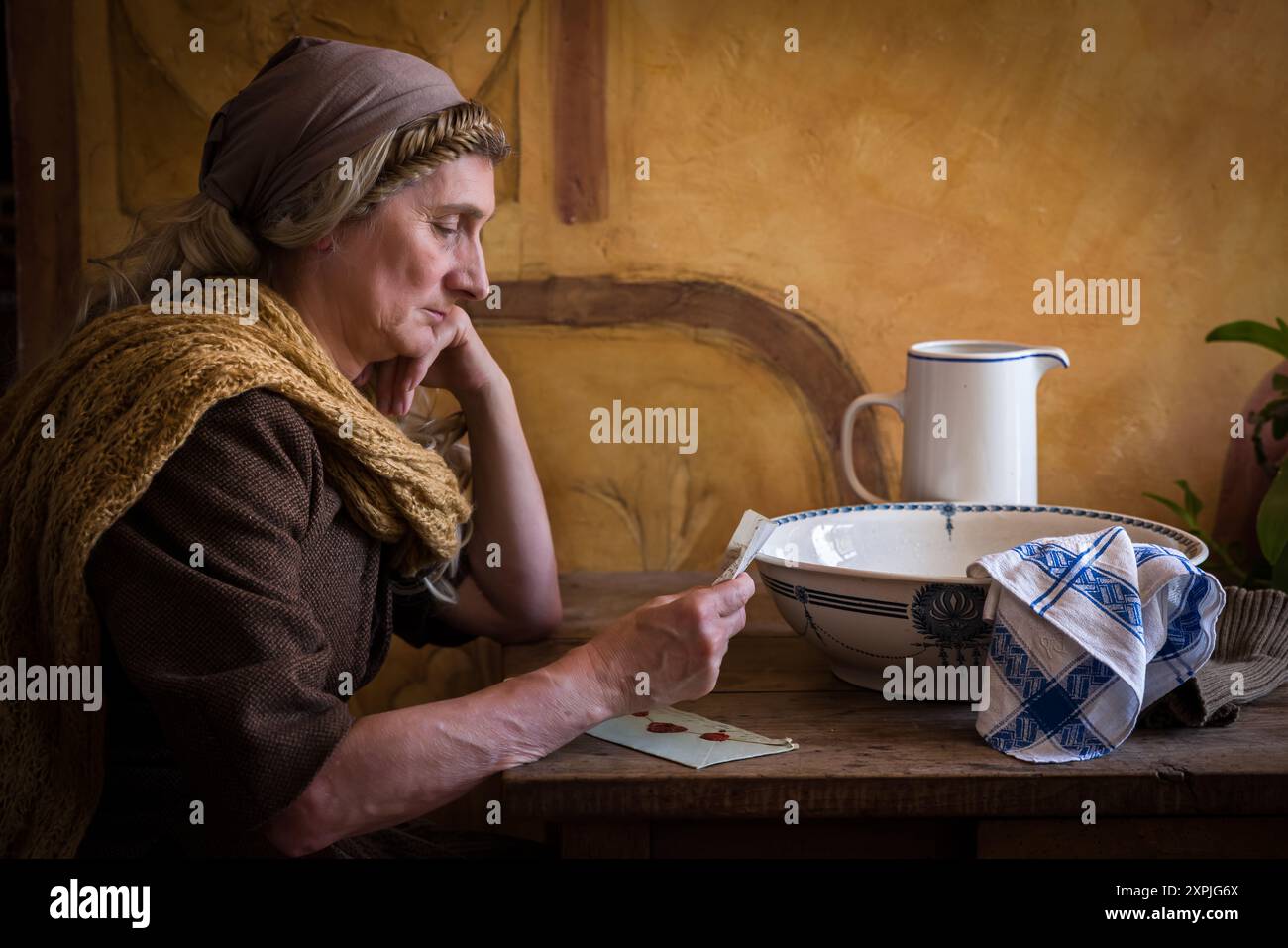 Eine Frau in authentischem Bauernrenaissance-Kostüm, die einen Brief liest Stockfoto